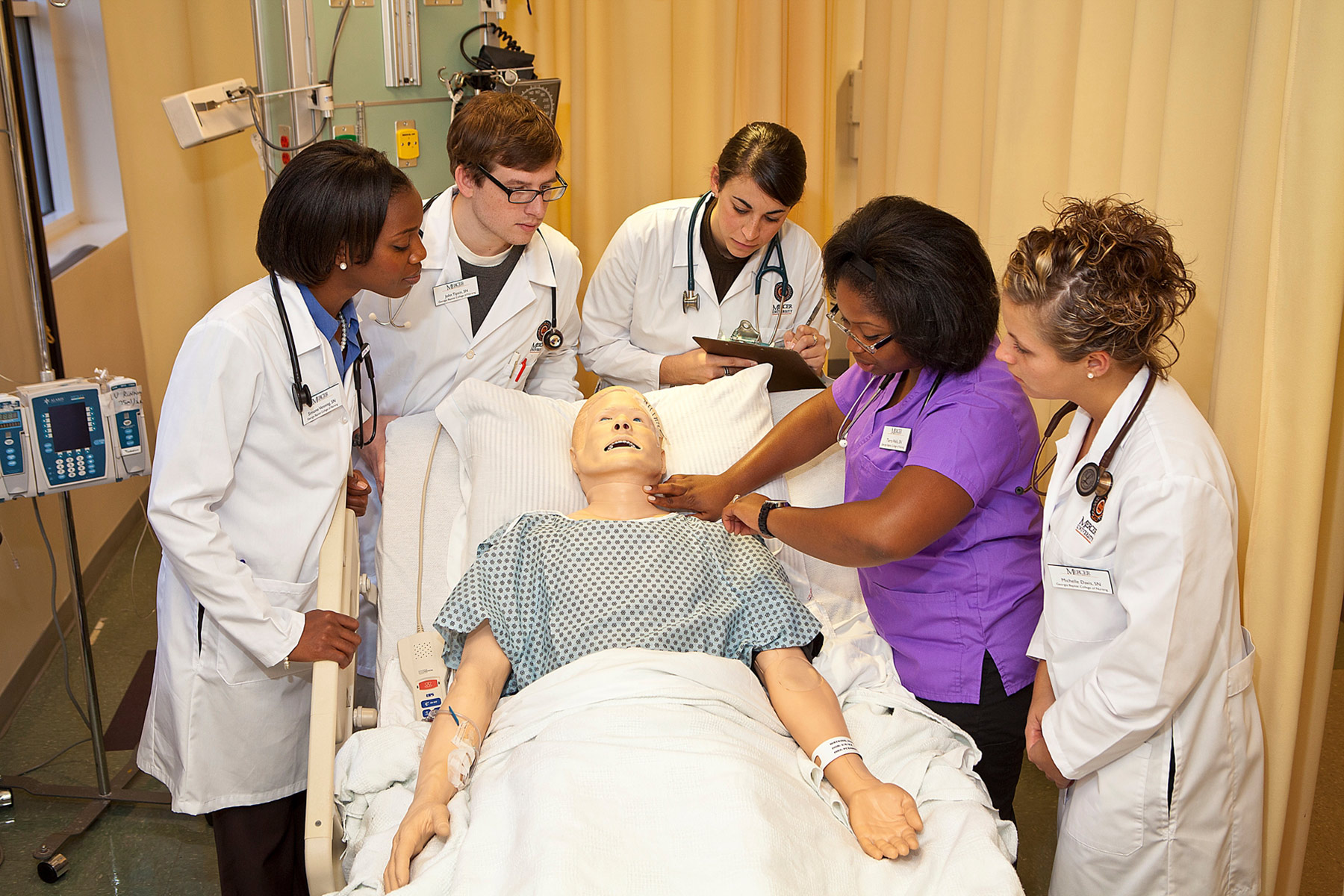 Nursing students gather around a teaching patient