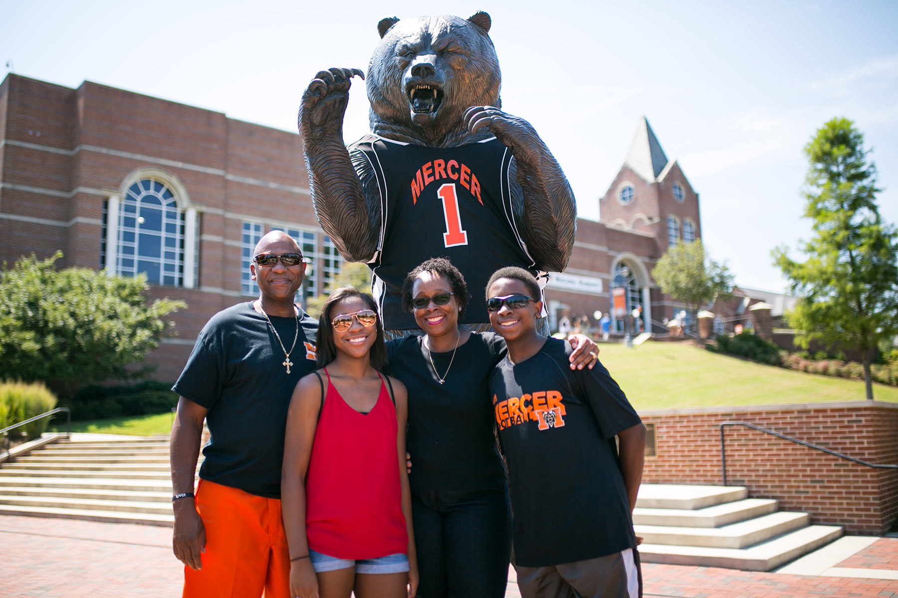 Family poses in front of bear statue
